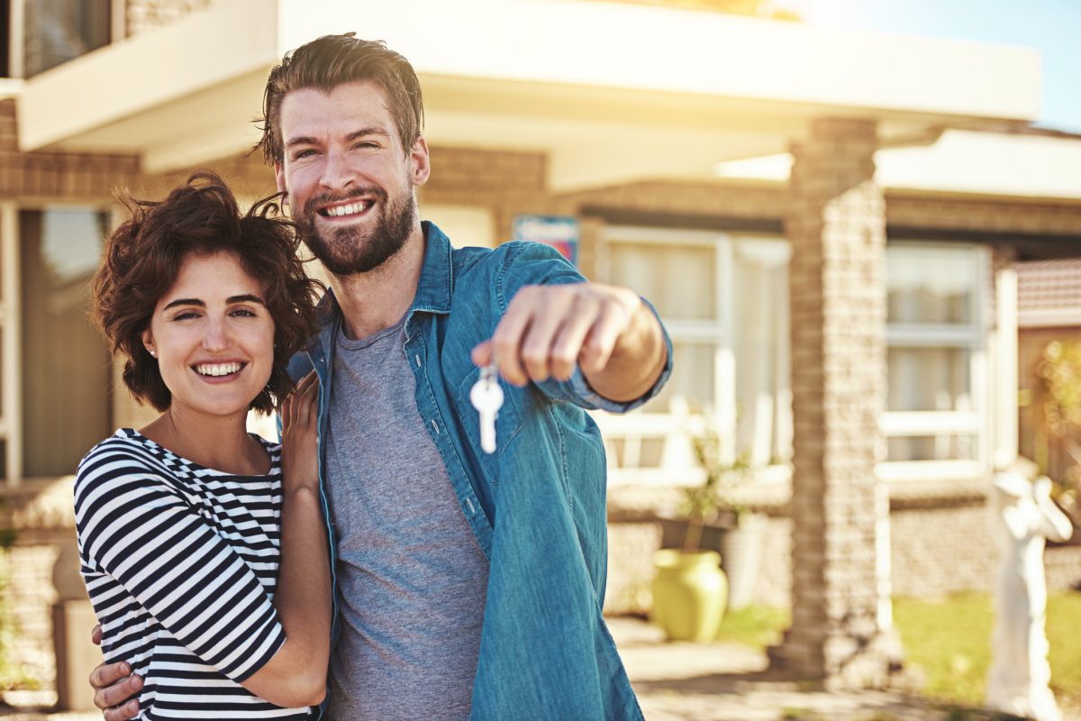 Happy couple in front of their new home