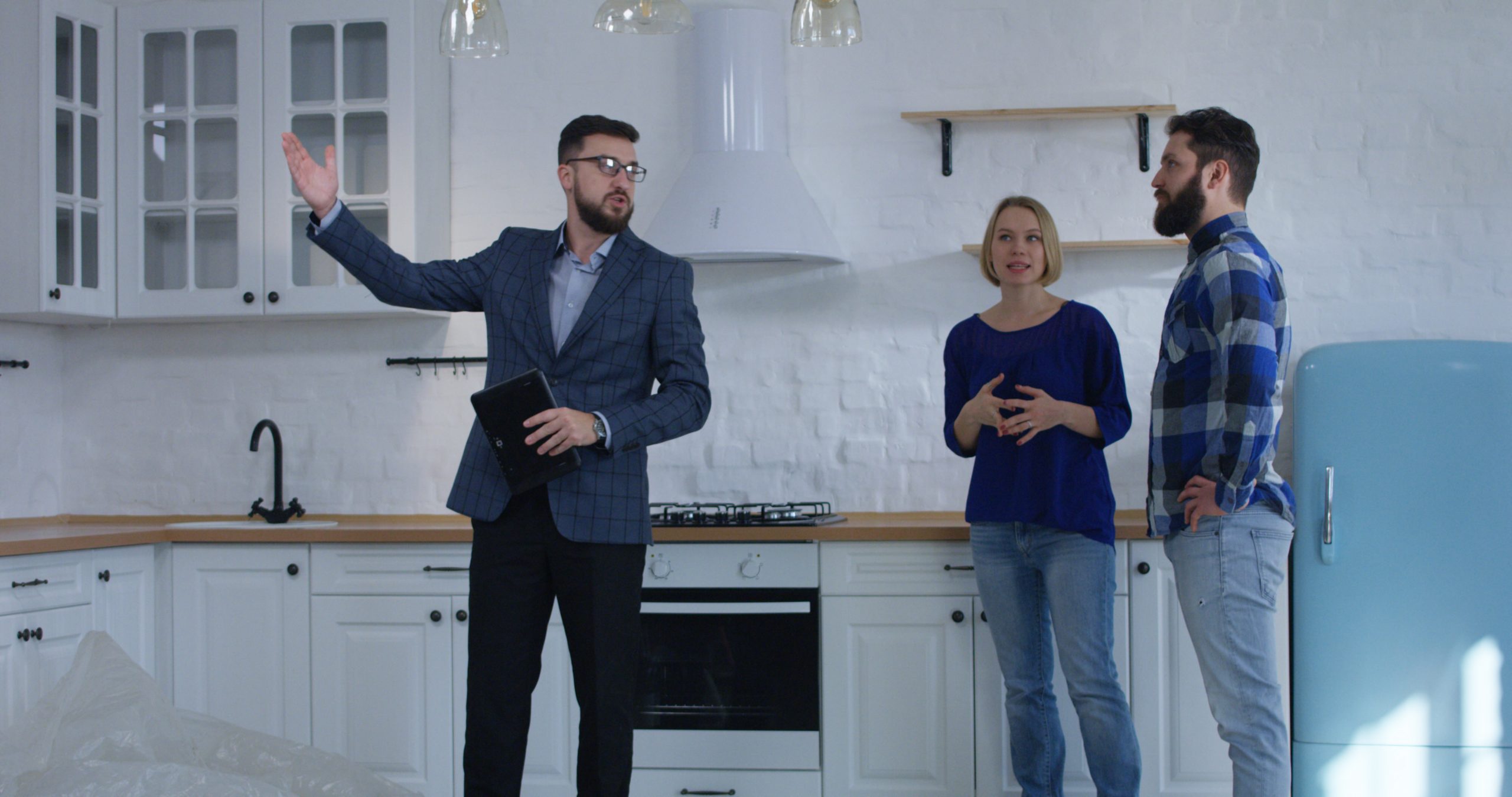 Real estate agent showing a young couple a home for sale.