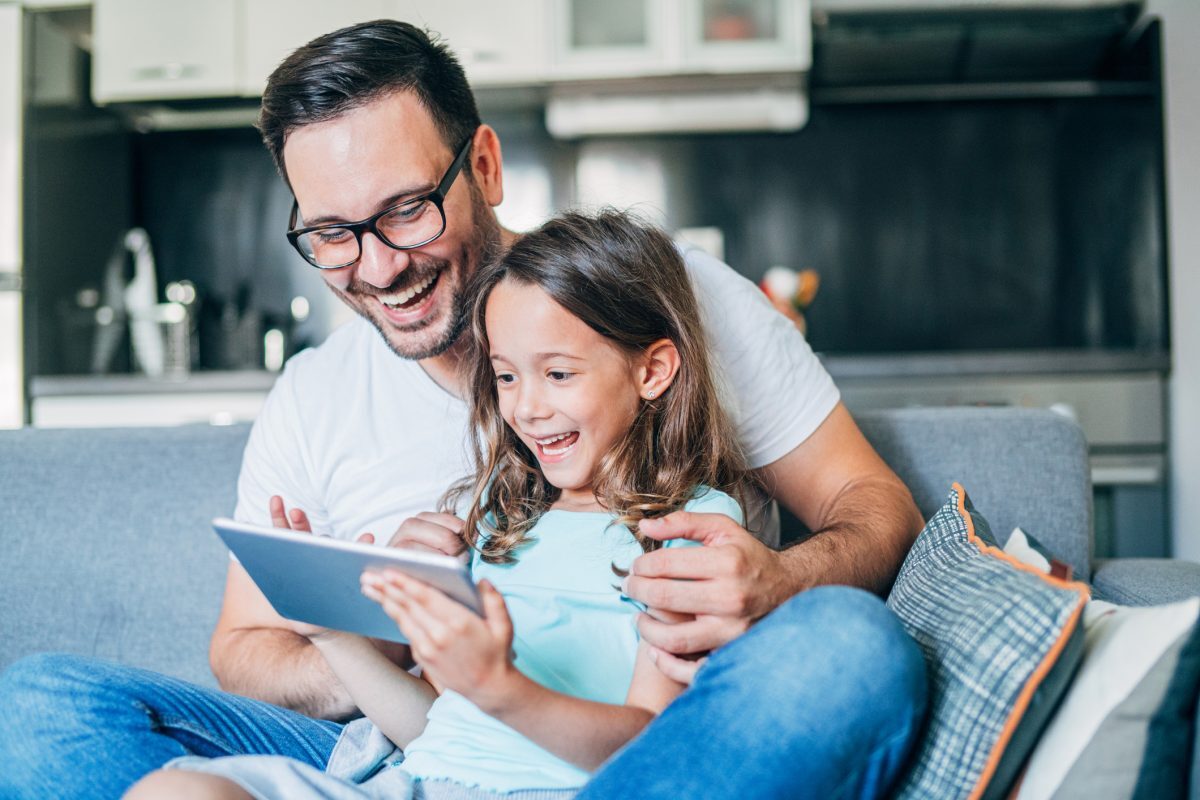 father showing daughter their new home on an ipad