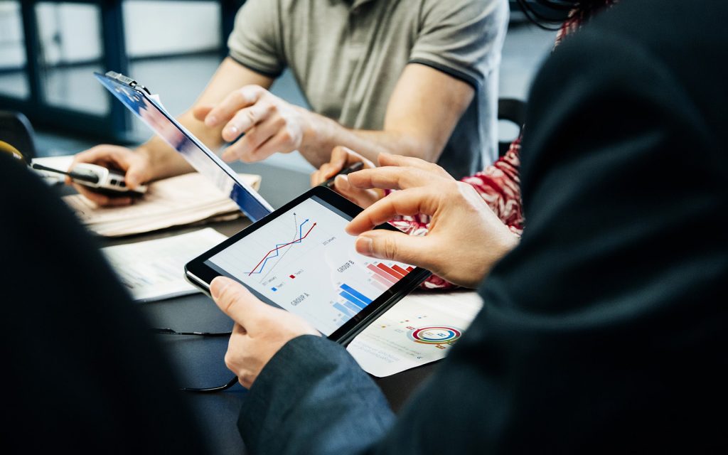 Colleagues reviewing relocation analytics on a tablet during a meeting