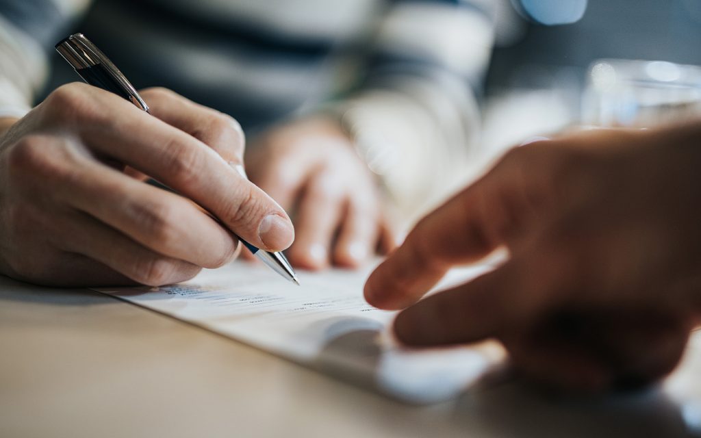 Close-up of a person signing a document