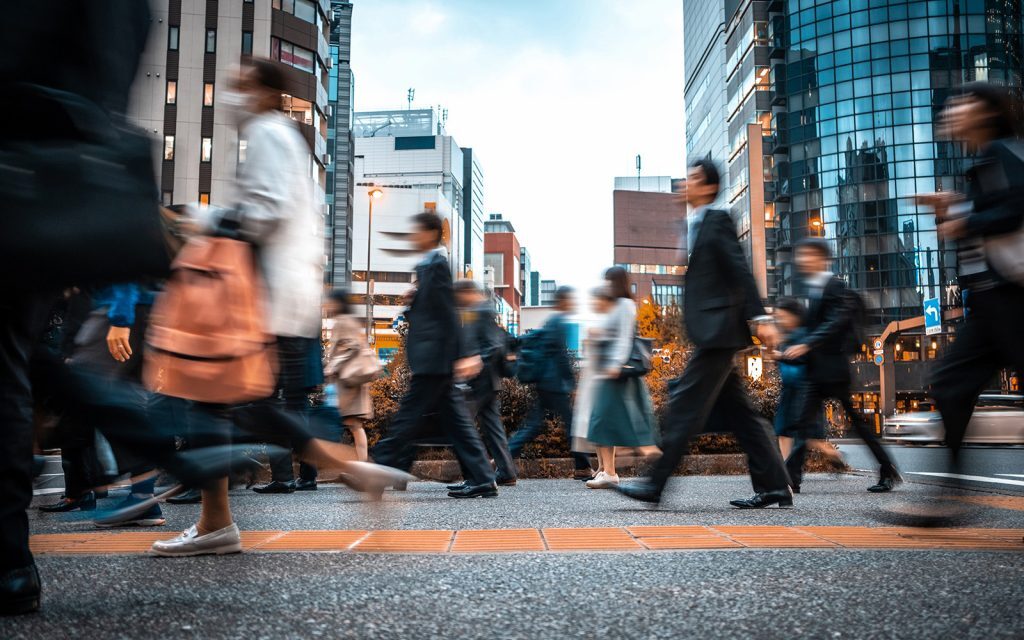 Commuters walking through a busy city street
