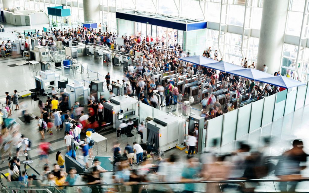 Crowded airport security checkpoint with travelers