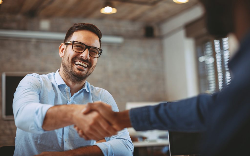 Man smiling and shaking hands with a colleague