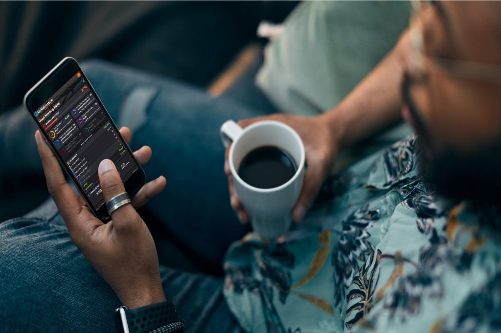 Person holding a phone and a cup of coffee