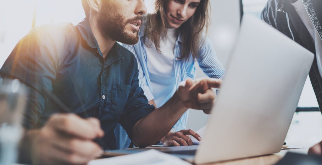 Colleagues reviewing information on a laptop together