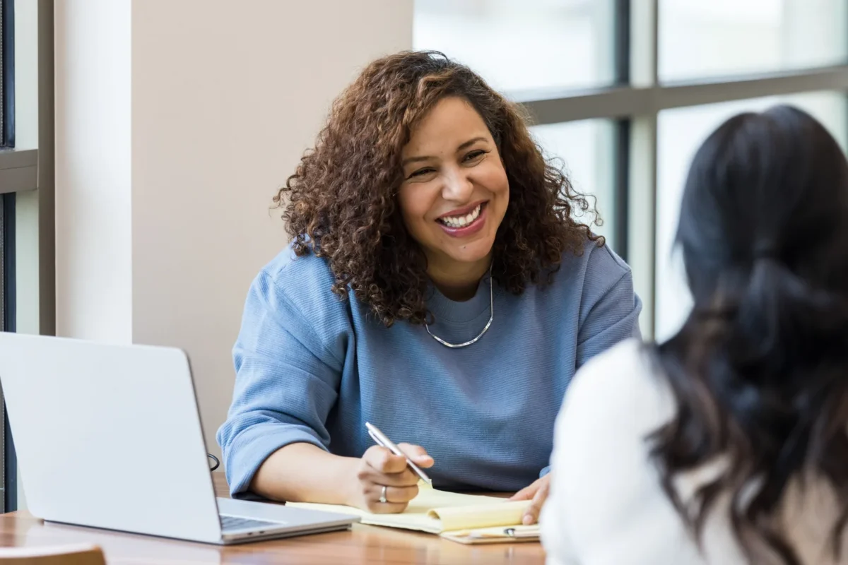 two women discuss relocation packages in a job interview